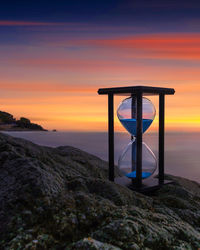 Hourglass with sunrise background on the beach in catalunya, barcelona, spain