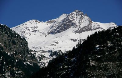 Scenic view of snowcapped mountains against clear blue sky