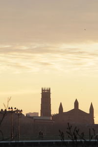 Silhouette buildings against sky during sunset