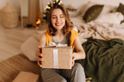 Portrait of young woman holding gift box