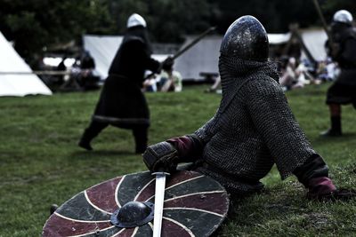 Warrior with sword and shield sitting on field