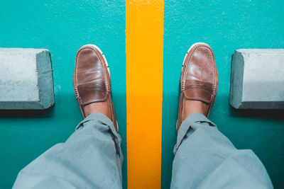 Low section of man standing on metal floor