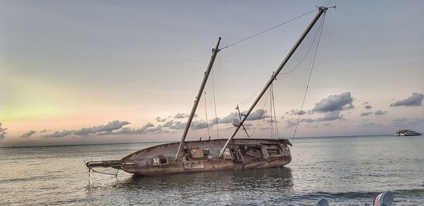 Sailboats on sea against sky during sunset