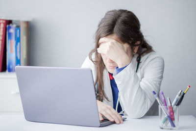 Woman using phone while sitting on table