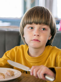 Close-up of boy looking away while sitting at cafe