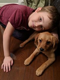 Portrait of boy with dog at home