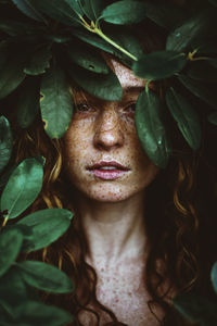 Close-up portrait of young woman with leaves