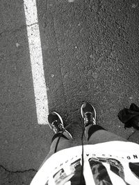 Low section of man standing on road