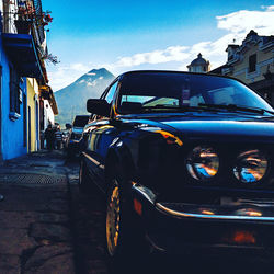 Cars on street against sky in city