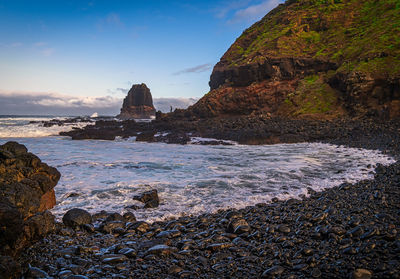 Rocks on beach against sky