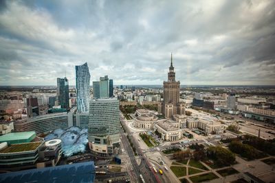 High angle view of city buildings against cloudy sky