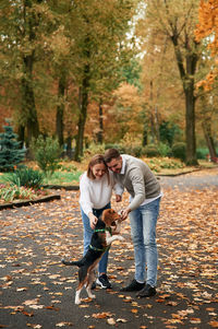 Portrait of young woman with dog on road