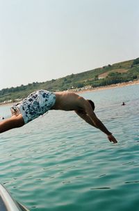 Man surfing in sea against clear sky