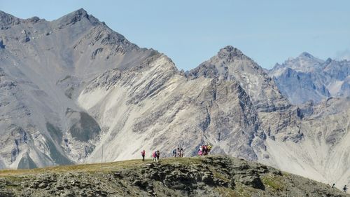 Panoramic view of people on snowcapped mountains against sky