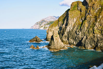 Scenic view of rocks in sea against sky