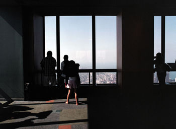 People looking through glass window of willis tower