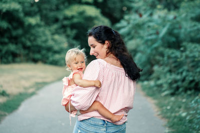 Happy mother and son on rock outdoors