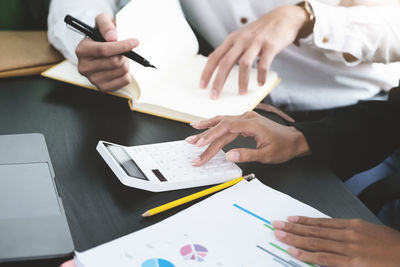 Cropped image of people working on table