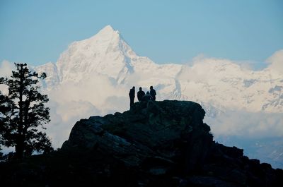 People on mountain against sky during winter