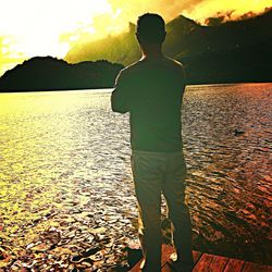 Rear view of silhouette man standing at beach