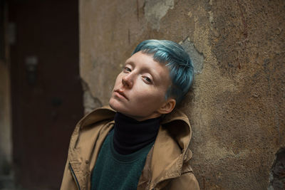 Portrait of woman standing against wall