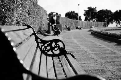 Wooden bench by footpath in park