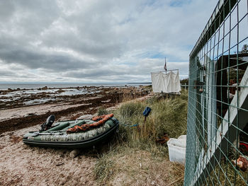 Abandoned boats moored on beach against sky