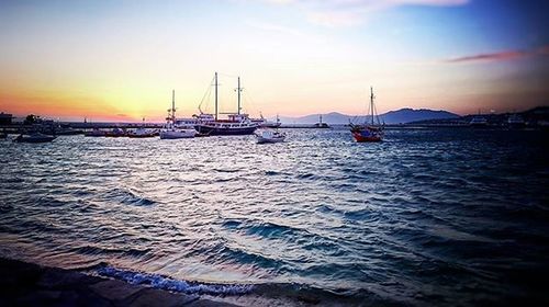 Sailboat in sea at sunset