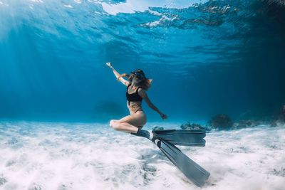 Rear view of woman swimming in sea