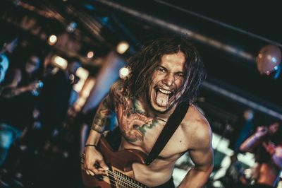 Portrait of shirtless young rock musician at nightclub