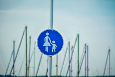 Close-up of road sign against blue sky