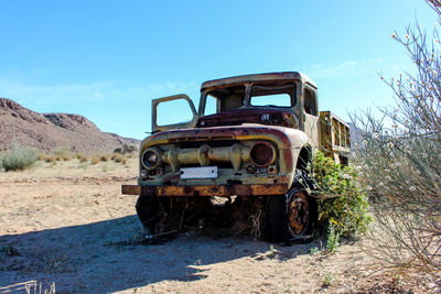 Abandoned truck on field against sky