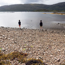 People standing on beach against sky