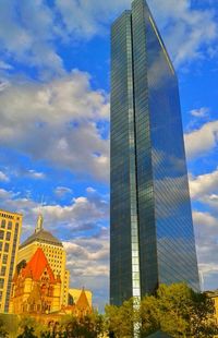 Low angle view of buildings against cloudy sky