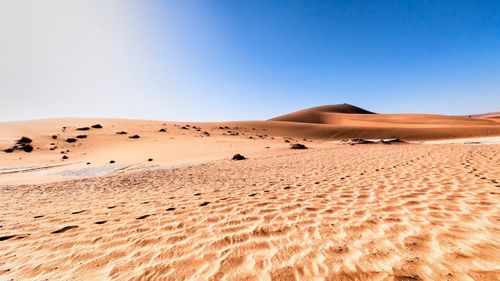 Scenic view of desert against clear blue sky