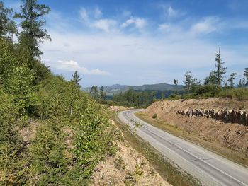 Road passing through landscape against sky