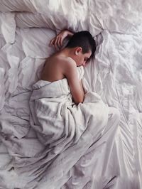 Directly above shot of boy sleeping on bed at home