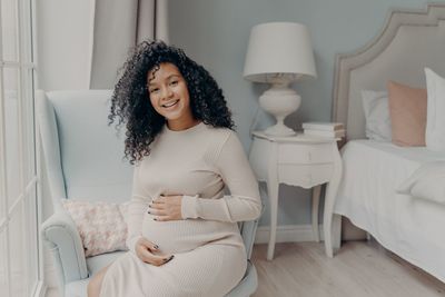 Smiling young woman sitting at home