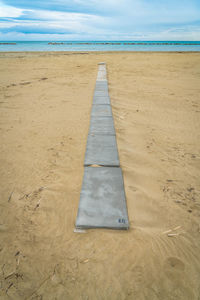 Surface level of sandy beach against sky