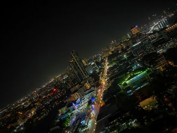 Low angle view of illuminated cityscape against sky at night