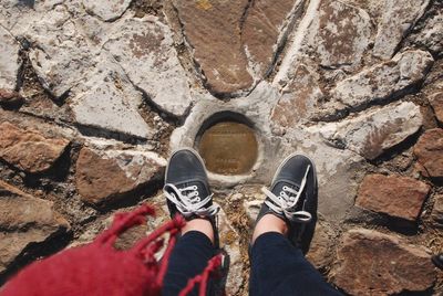 Low section of man standing on rock
