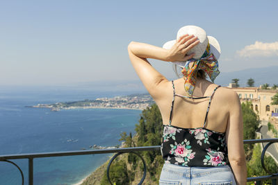 Woman looking at sea against sky