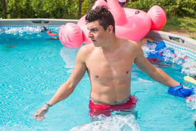 Full length of shirtless man in swimming pool