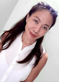 Portrait of beautiful woman against white wall