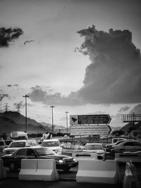 Cars on road by city against sky