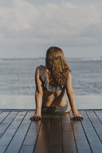 Rear view of woman looking at sea against sky
