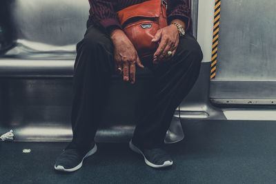 Low section of man sitting in train