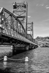 Low angle view of lift bridge over river against sky