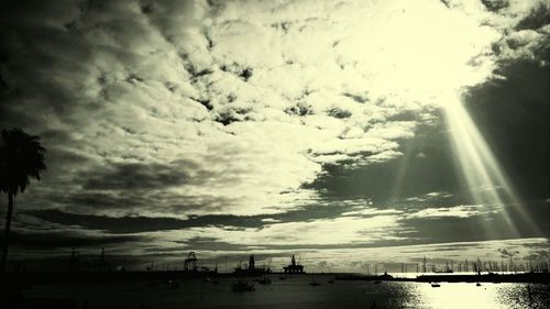 View of sunlight streaming through silhouette people in water