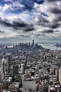 Aerial view of cityscape against cloudy sky